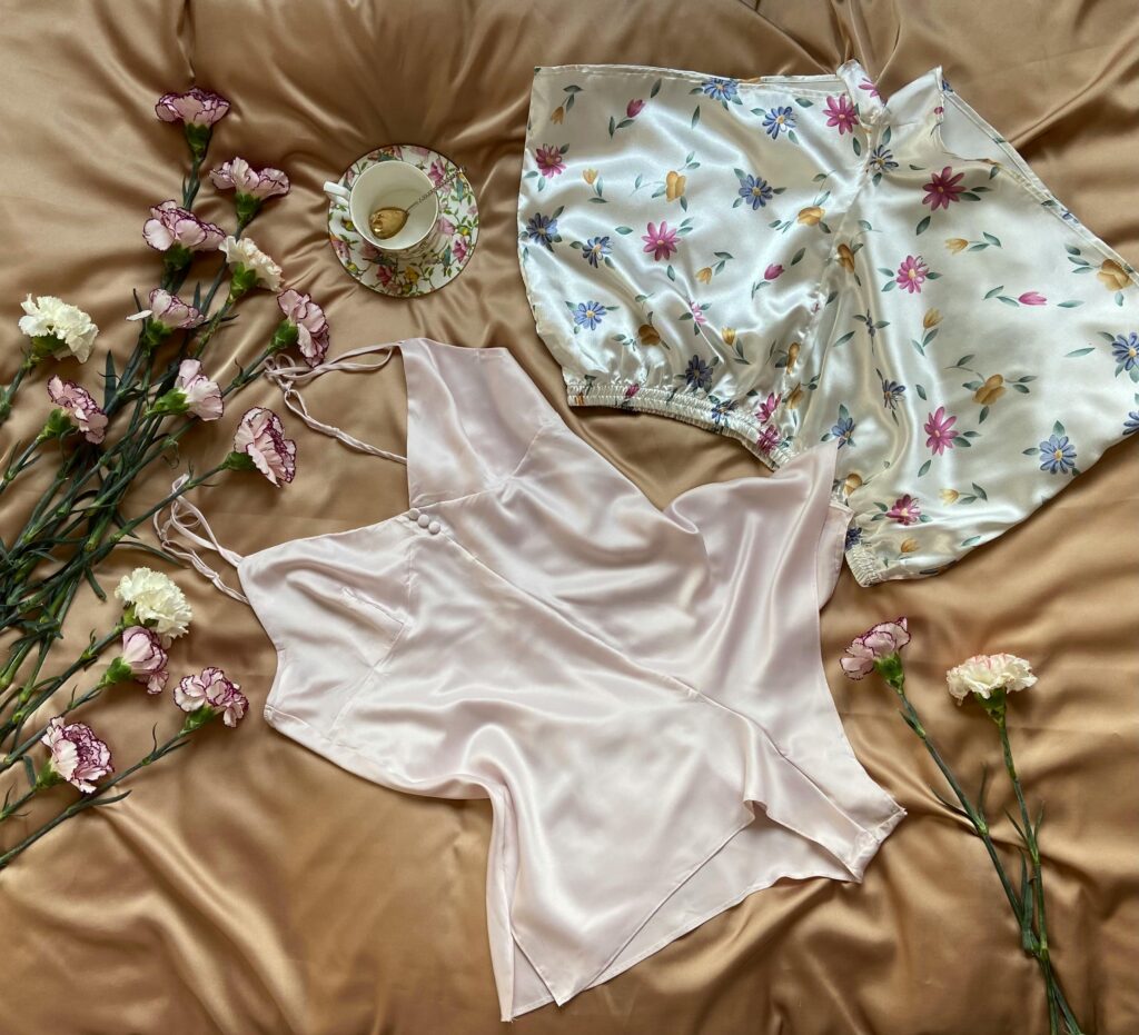 Luxury Pajamas Silk pajamas with floral design and a teacup surrounded by flowers.